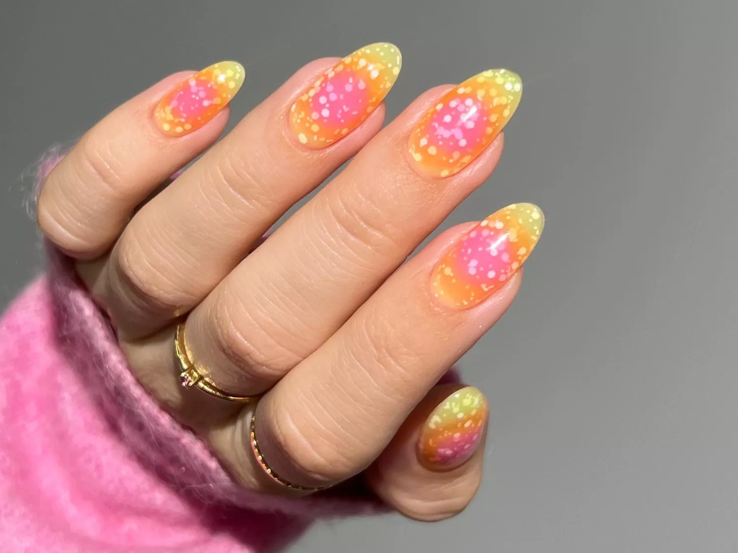 Manicure with pink and yellow ombre aura base and confetti texture