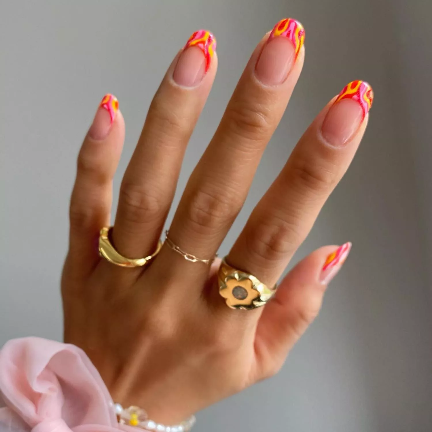 French manicure with pink, red, and yellow wavy tip design