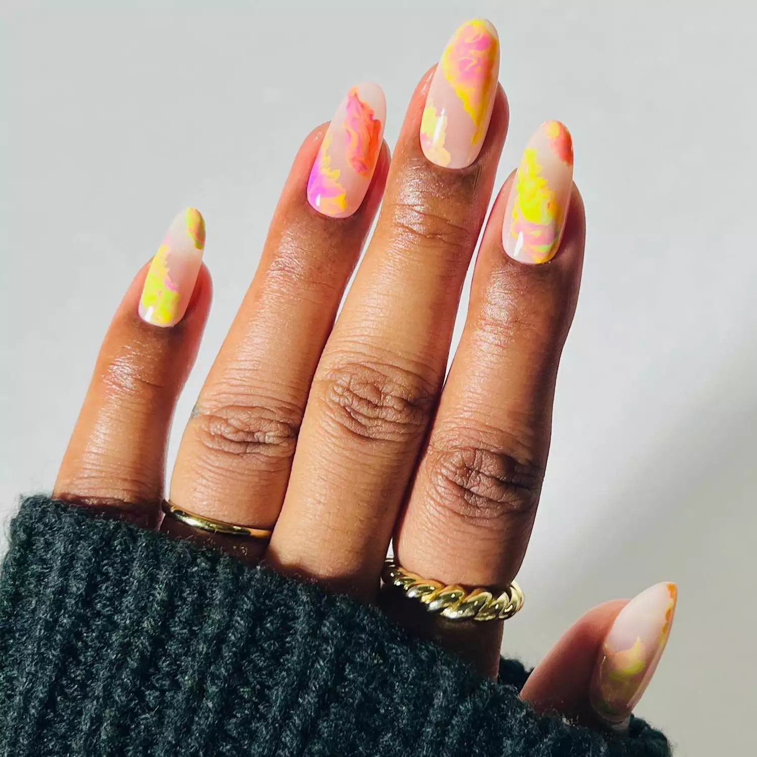 Marbled pink and yellow manicure on translucent neutral base